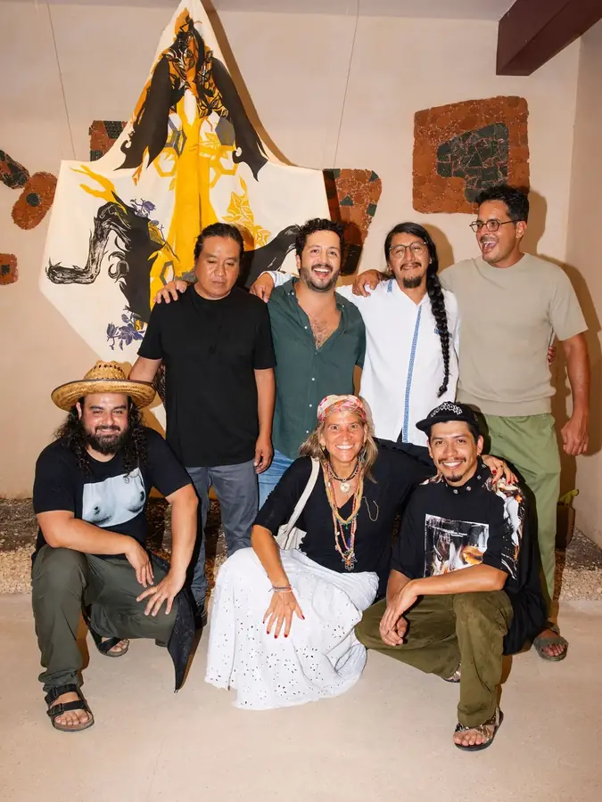 Retrato grupal de los artistas de la primera edición frente a una obra textil
